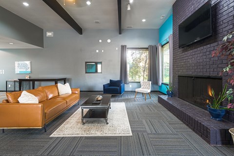 a living room with a leather couch and a fireplace